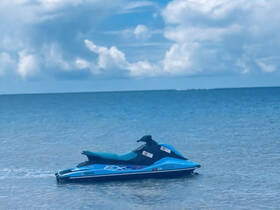 A vibrant Yamaha jet ski rests on calm waters, perfect for thrilling water adventures and exploring coastal areas.