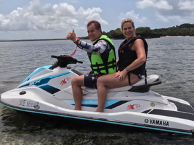 A couple enjoys a thrilling ride on a jet ski, showcasing smiles and excitement in the beautiful waters — perfect for adventure seekers.