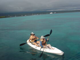 A couple enjoys kayaking in the stunning turquoise waters, showcasing the perfect adventure for water enthusiasts.