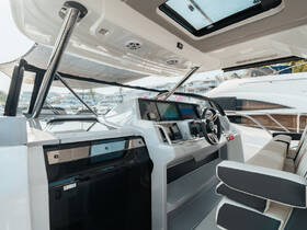A sleek and modern helm area of a boat featuring advanced navigation screens and comfortable seating, perfect for enjoying a day on the water.