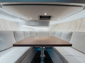 Interior view of a stylish boat cabin featuring a spacious dining area with comfortable seating, perfect for relaxing meals on the water.