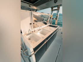 A sleek and modern boat interior featuring a well-equipped console with dual sinks, perfect for onboard dining and entertaining.