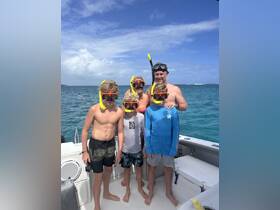 A family of five prepares for a snorkeling adventure, showcasing excitement and togetherness on the water. Perfect for family outings and aquatic explorations.