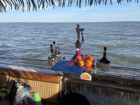 A well-equipped bar area on a boat featuring fresh oranges and various spirits, perfect for crafting refreshing cocktails while enjoying the water.