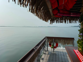 A serene view from the lounge area of a boat, showcasing a calm water surface and distant islands, perfect for relaxation and enjoying the scenery.