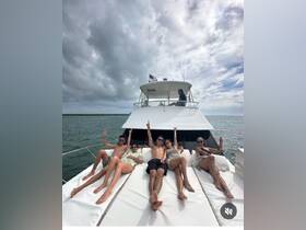 A lively group enjoys sunbathing on the deck of a yacht, capturing the essence of a fun day on the water with friends.