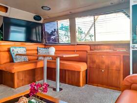 A cozy interior view of a boat's lounge area, featuring comfortable seating and a modern TV, perfect for relaxing during a day on the water.