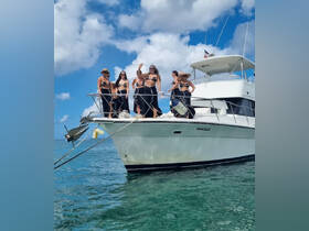 A lively group of friends celebrates aboard a yacht, enjoying the sun and sea — perfect for unforgettable party experiences on the water.
