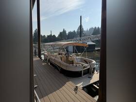 A beautiful pontoon boat docked at a serene waterfront, showcasing its spacious seating and stylish design — perfect for leisurely outings on the water.