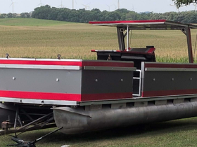 A sleek pontoon boat is showcased in a serene setting, highlighting its modern design and features, perfect for leisurely outings on the water.