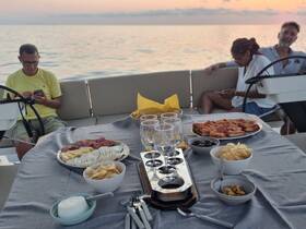 A beautifully arranged spread of food and drinks on a boat, featuring a variety of snacks and appetizers, perfect for enjoying a relaxing evening on the water.
