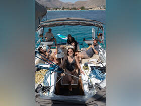 A lively group enjoys a sunny day aboard a yacht, sharing food and drinks while soaking in the beautiful surroundings — perfect for a fun day on the water.