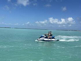 A couple enjoys an exhilarating ride on a jet ski in crystal-clear waters, showcasing the thrill of water sports and adventure on the open sea.