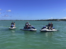 A group of friends enjoys an exhilarating day on jet skis, racing across the turquoise waters — perfect for adventure seekers and water sports enthusiasts.