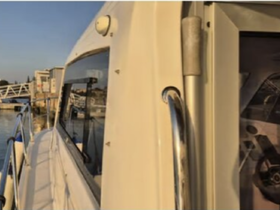 A close-up view of the side of a boat docked at a marina, showcasing its sleek design and surrounding environment.