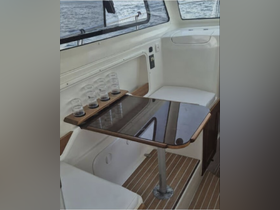 Interior view of a boat's cabin featuring a sleek table and seating area, perfect for relaxing or dining while enjoying the water.