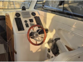 A detailed view of the helm and console inside a boat, showcasing the steering wheel and control panel — perfect for understanding the vessel's navigation features.