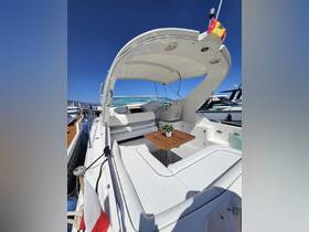 A stylish interior view of a boat's lounge area featuring comfortable seating and a wooden table, perfect for relaxing on the water.