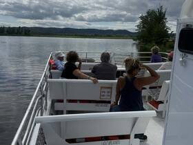 A group of guests enjoys a scenic boat ride, taking in the beautiful views of the water and surrounding landscape.