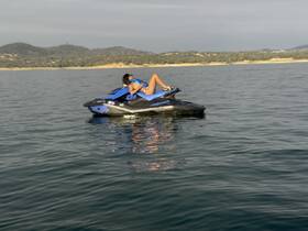 A rider enjoys a thrilling moment on a jet ski, gliding across calm waters surrounded by scenic hills — perfect for adventure seekers and water sports enthusiasts.