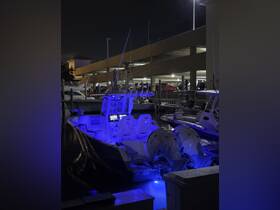 A striking view of a boat illuminated with blue lights at night, docked in a marina — perfect for evening outings and fishing adventures.