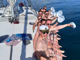 A lively group of friends enjoys a fun day sailing, showcasing their playful spirit with matching hats and smiles. Perfect for celebrating special occasions on the water.