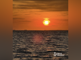 A stunning sunset over the ocean, casting vibrant colors across the water — a perfect backdrop for evening boat cruises.