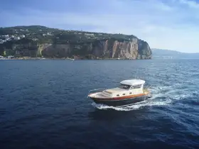 A stunning yacht cruises through clear waters, showcasing its elegant design against a picturesque coastal backdrop.