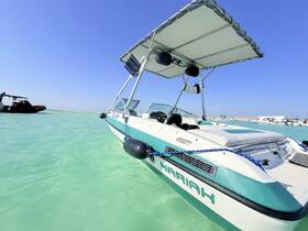 A sleek speedboat named 'Mariah' is anchored in clear turquoise waters, showcasing its stylish design and perfect for a day of fun on the water.