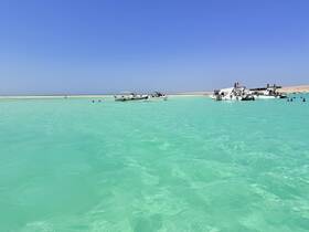 A vibrant scene at a sandbar with multiple boats and people enjoying the clear turquoise waters — perfect for a fun day out on the water.