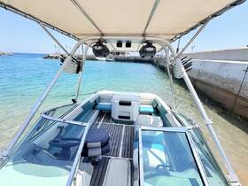 A view of the helm and seating area inside a boat, showcasing a comfortable and stylish interior perfect for a day on the water.