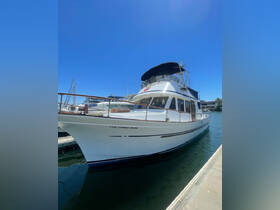 A pristine view of 'The Long Run' yacht docked at the marina, showcasing its elegant design against a clear blue sky.