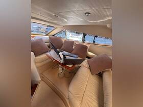 A cozy interior view of a boat cabin featuring a comfortable seating area with a workspace setup, perfect for enjoying the sea while staying connected.