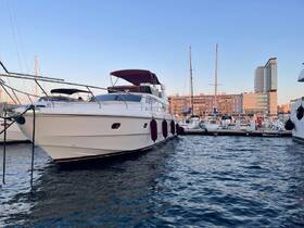A stunning yacht docked in a marina, showcasing its elegant design against a backdrop of modern buildings and clear skies.