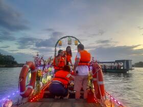 A lively group of friends wearing life jackets prepares for an evening boat ride, surrounded by colorful decorations and a picturesque sunset — perfect for memorable celebrations on the water.