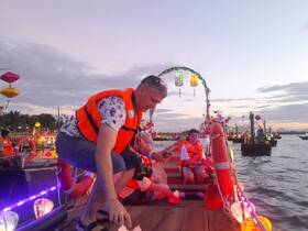 A lively group enjoys a festive evening on a decorated boat, showcasing the vibrant atmosphere of a local celebration on the water.
