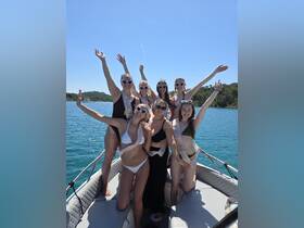 A lively group of friends celebrates a bachelorette party on a boat, enjoying the sun and water — perfect for memorable summer outings.