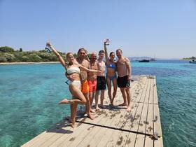 A joyful group poses on a dock, ready for a day of swimming and snorkeling in the crystal-clear waters — perfect for summer adventures and memorable outings.