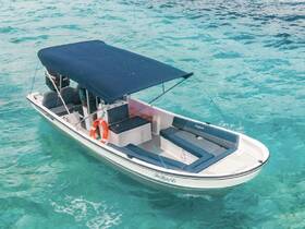 A sleek speedboat glides through crystal-clear waters, showcasing its spacious seating and canopy — perfect for a day of adventure on the water.