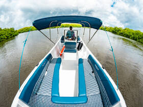 A view of the interior of a boat featuring comfortable seating and a helm, perfect for navigating through scenic waterways.