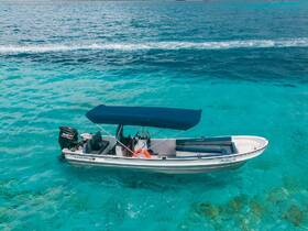 A stunning aerial view of a sleek speedboat cruising through crystal-clear turquoise waters, perfect for exploring coastal destinations.