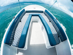 A spacious interior view of a boat's seating area, featuring comfortable cushions and a sleek design, perfect for relaxing on the water.