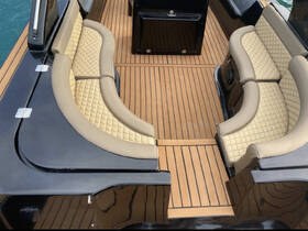 Interior view of a stylish boat seating area featuring plush cushions and elegant wood flooring, perfect for relaxing on the water.