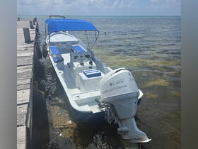 A center console boat docked at a pier, showcasing its sleek design and comfortable seating, perfect for a day on the water.