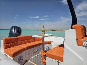 A stylish interior view of a boat featuring plush orange seating and a bottle of champagne on the table, perfect for relaxing on the water.