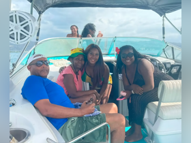 A joyful group of friends enjoys their time aboard a boat, capturing memories and celebrating together under the sun.