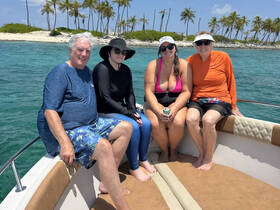 A cheerful group of friends enjoys a sunny day on the boat, surrounded by beautiful tropical scenery — perfect for memorable outings and celebrations on the water.