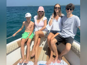 A cheerful family enjoys a sunny day on the boat, capturing the essence of fun and togetherness on the water.
