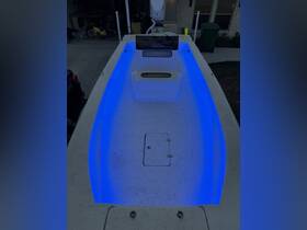 An interior view of a boat's helm featuring illuminated seating and console, showcasing modern design and functionality.