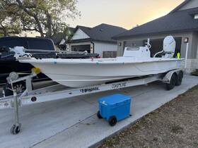 A pristine white boat is showcased on its trailer, parked in a residential area, highlighting its sleek design and features.